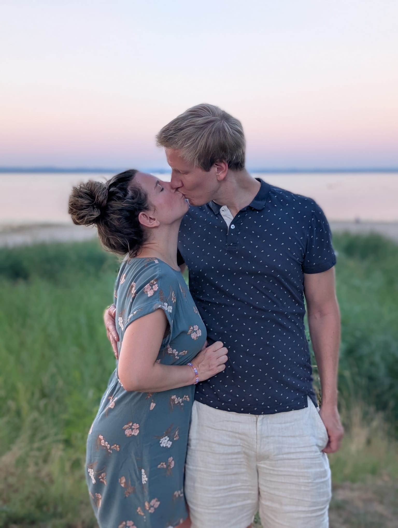Kerstin und Daniel küssen sich am Wasser.